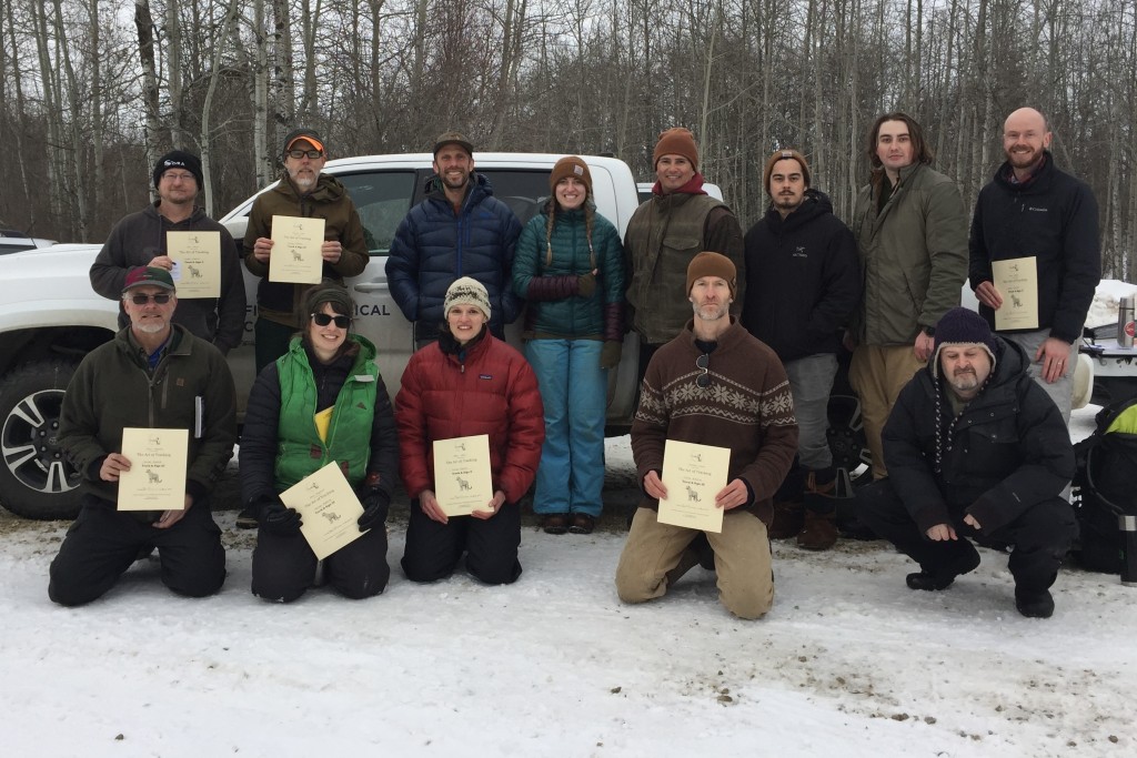 A group of workshop participants pose with their certifications.