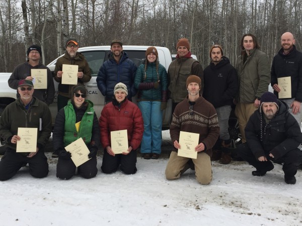 A group of workshop participants pose with their certifications.